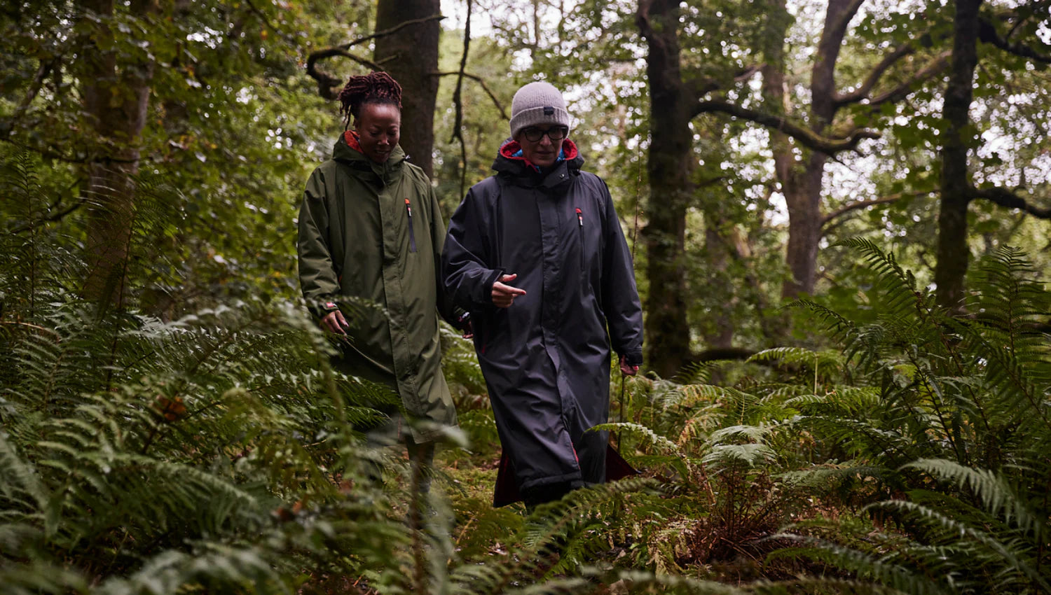 2 people walking through the forest wearing the Red Pro Change Robe