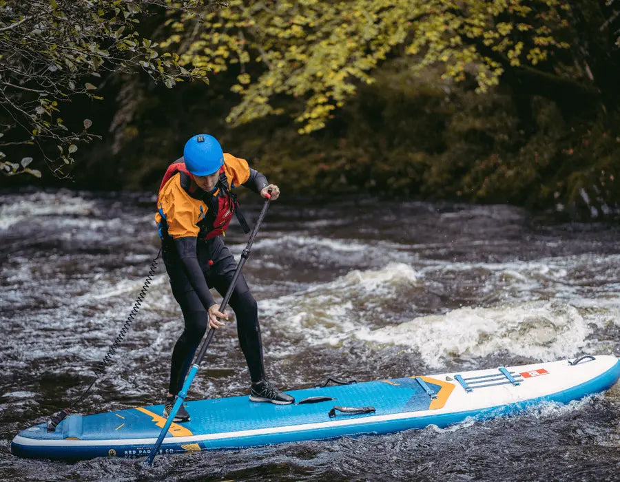 A man paddleboarding in the rapids