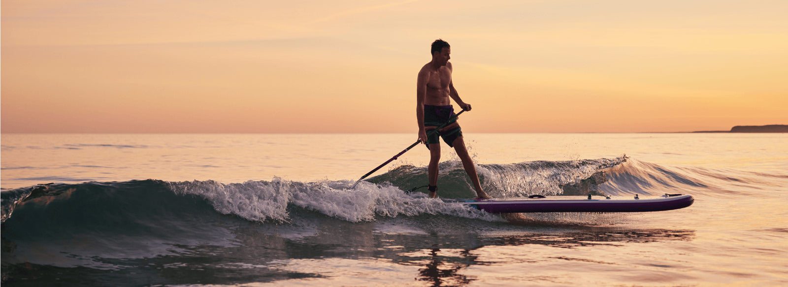 A man paddleboarding standing up in the sea