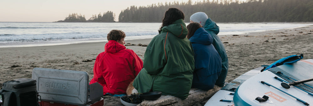 family wearing changing robes on the beach
