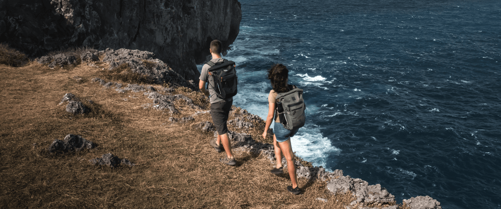 man and woman hiking with waterproof backpacks