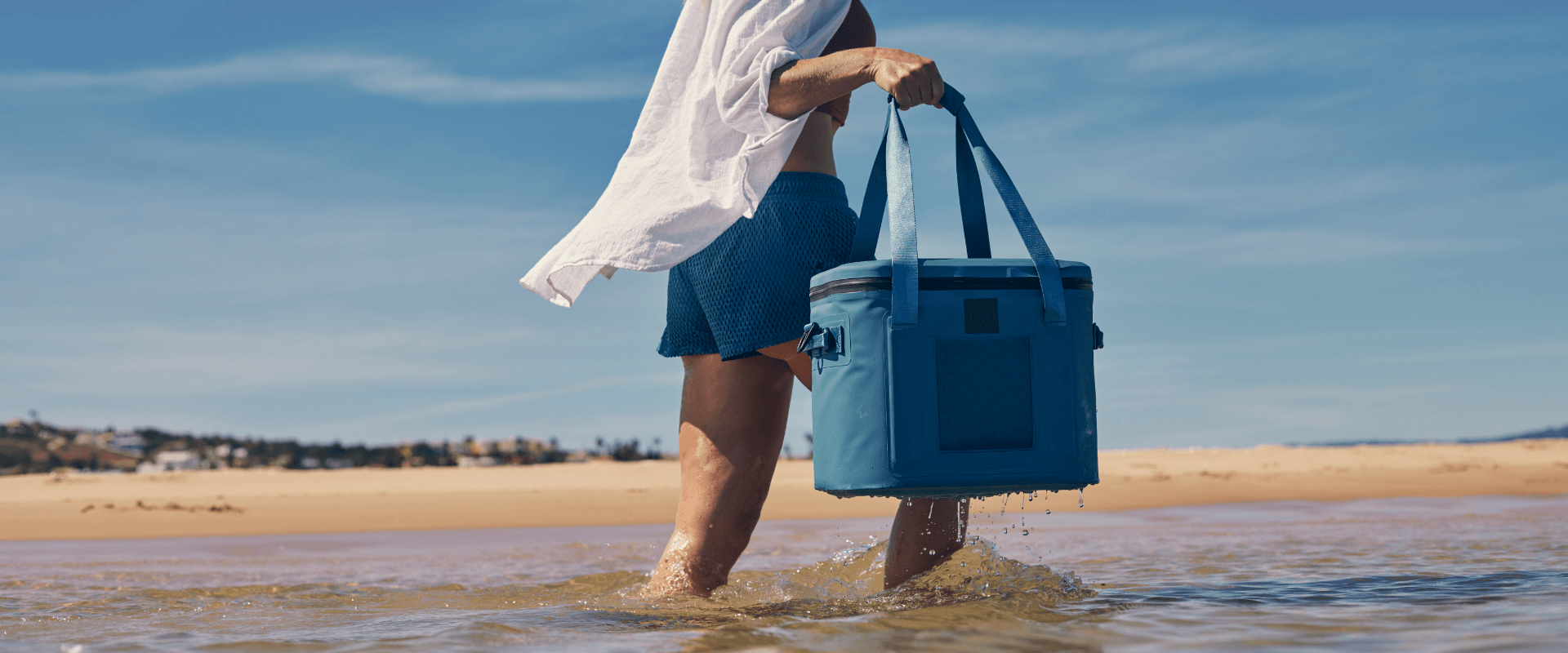 man carrying waterproof soft cooler bag in water