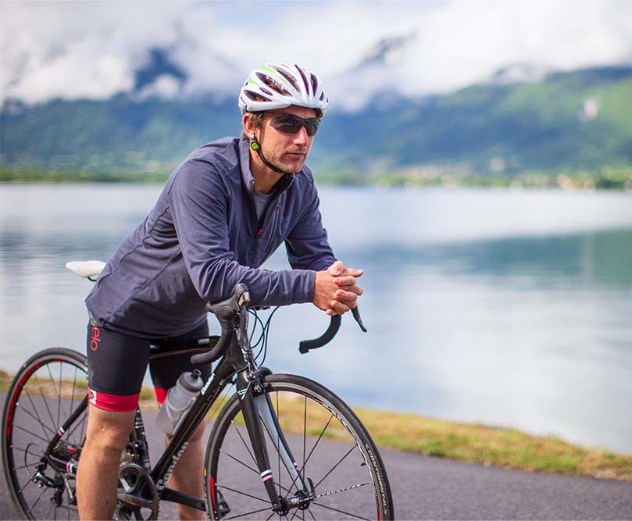 Man sat on bicycle wearing Red Original long sleeved top