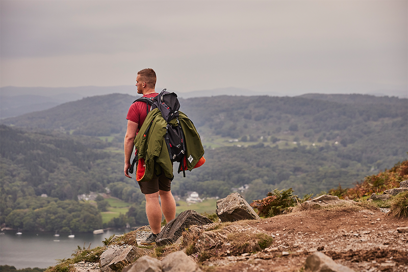 Man looking into distance whilst carrying Red Original Pro Change Rove in parker green