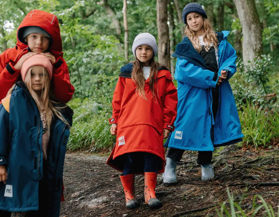 4 children wearing the Red Kids Pro Change Robe in the woods