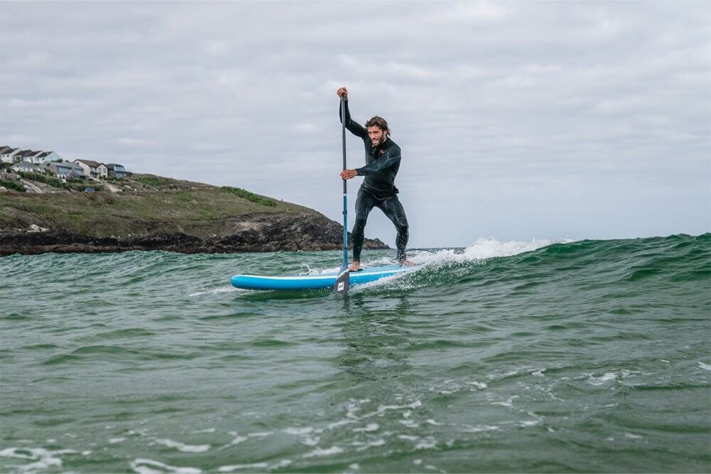 man paddling on Whip MSL inflatable paddle board through the surf