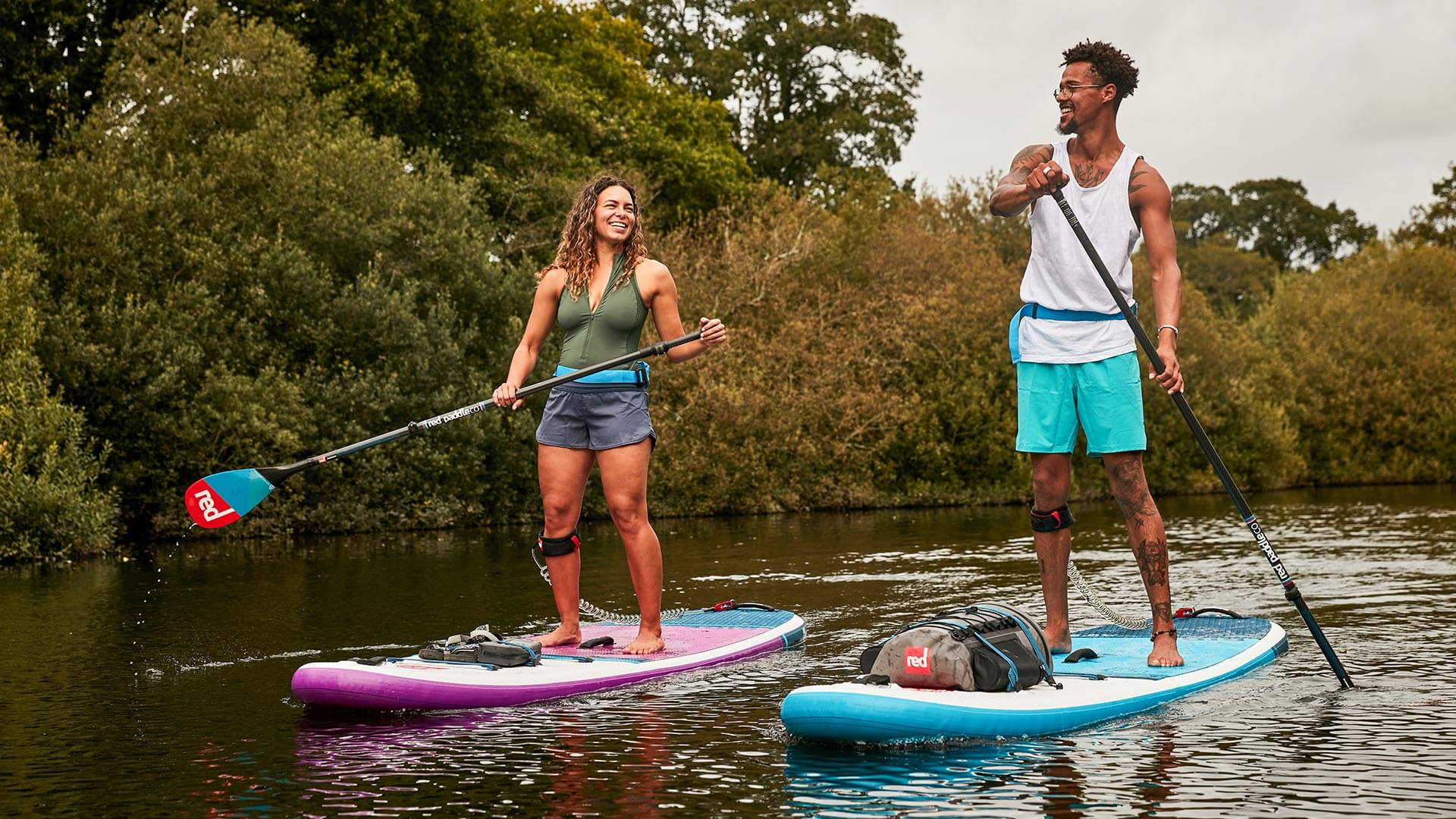 two people paddling on Red inflatable paddle boards alongside each other