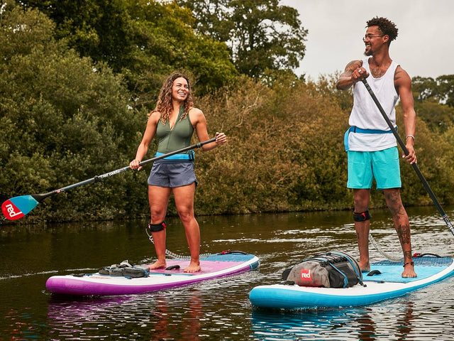 two people paddling on Red inflatable paddle boards alongside each other