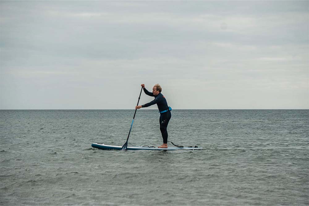 Man paddle boarding in bleak weather