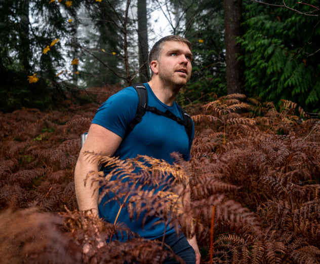 Man walking through woodland wearing Red Original Performance t-shirt