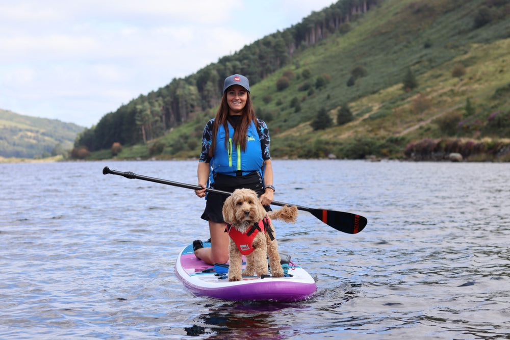 Woman paddleboarding with her dog on a Lake