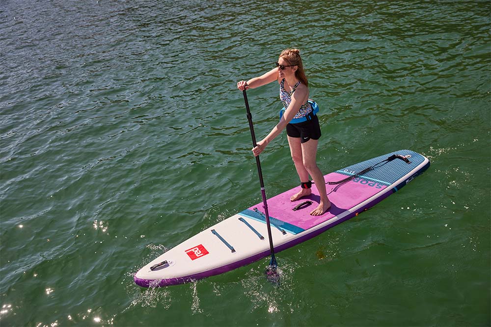 Woman paddling Red Original sport MSL paddle board in the sea