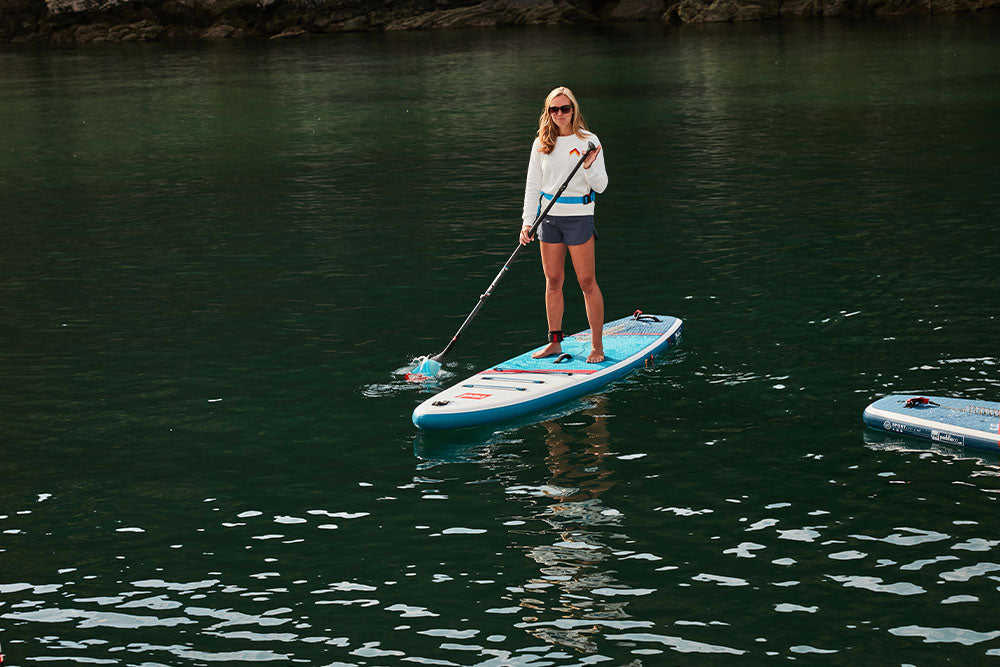 Woman paddleboarding using Red Paddle Co Board