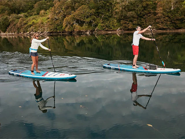 Man and woman on a lake paddling touring SUP board