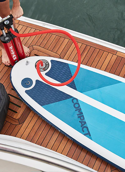 A paddleboard being pumped up on a boat